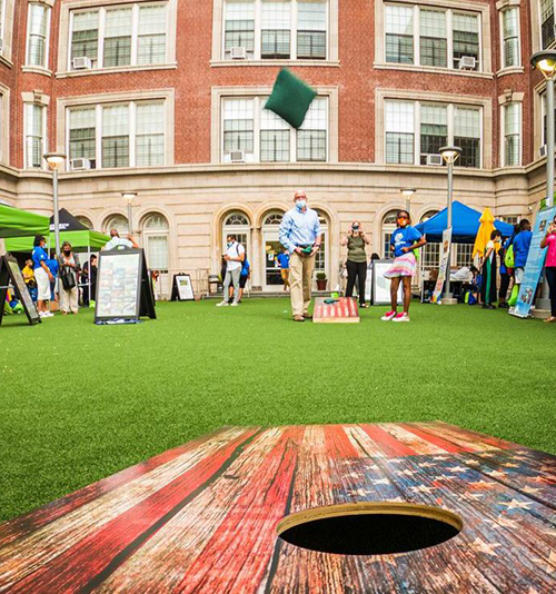 cornhole being played on artificial grass