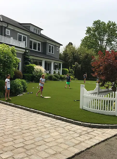 Kids playing on artificial grass front lawn